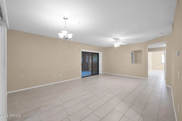 an empty room with chandelier and windows