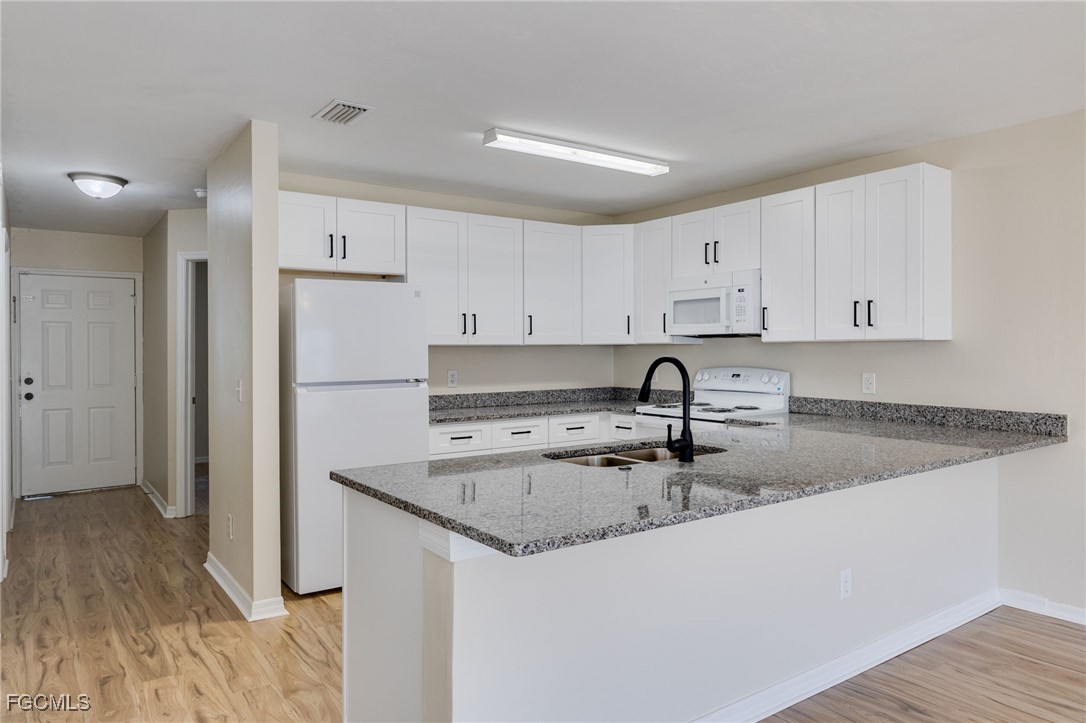 5304 Glenlivet Road Fort Myers, FL 33907 - Photo 2 of 19 a kitchen with stainless steel appliances granite countertop a sink a refrigerator and white cabinets