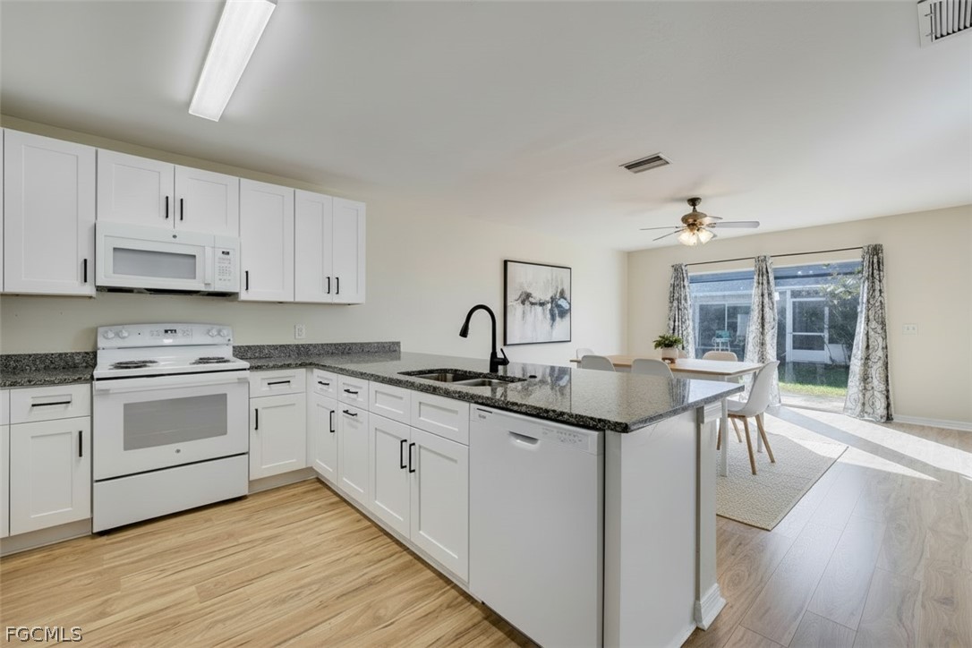 5304 Glenlivet Road Fort Myers, FL 33907 - Photo 3 of 19 a kitchen with granite countertop white cabinets and white appliances