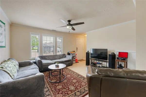a living room with furniture a flat screen tv and a window
