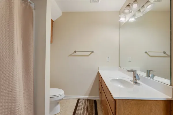 a bathroom with a sink a toilet a light fixture and a mirror