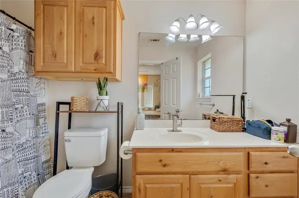 a bathroom with a toilet a sink and mirror