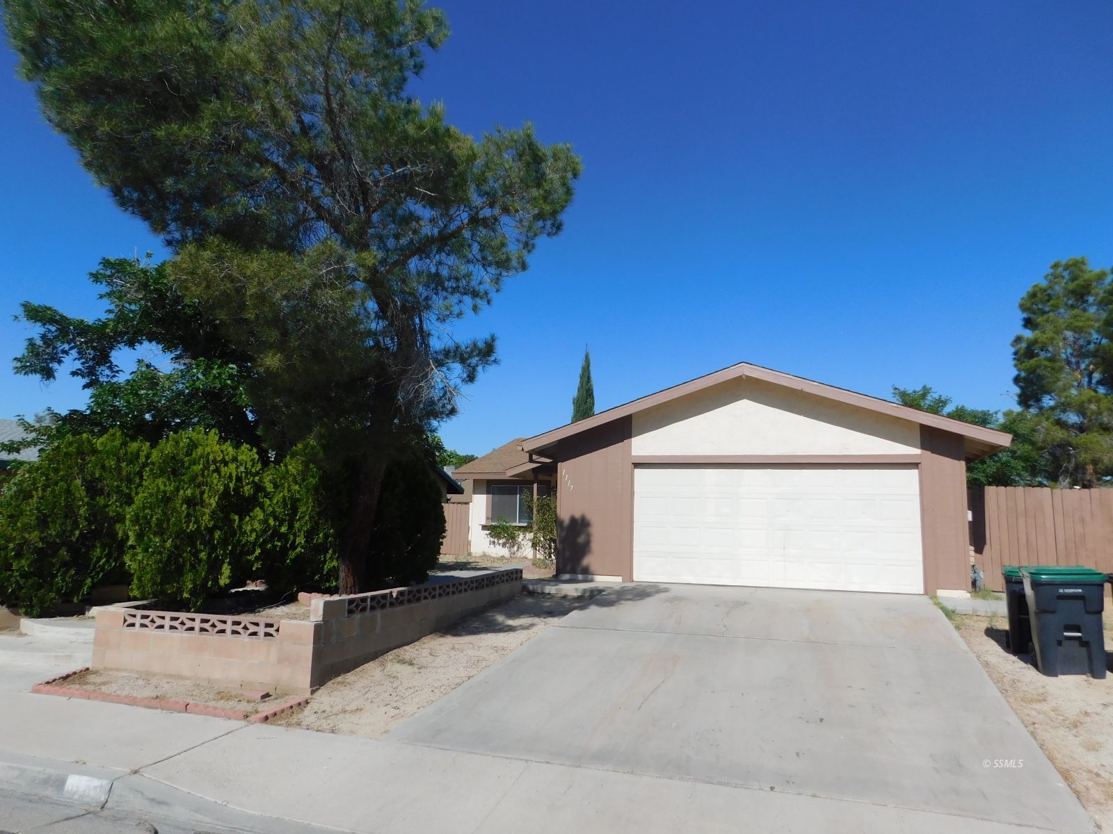 1117 North Sierra View Street Ridgecrest, CA 93555 - Photo 1 of 17 a front view of a house with a yard and garage