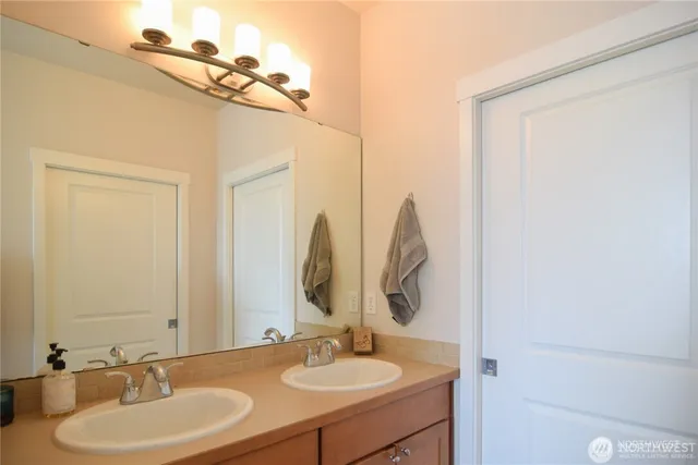 a bathroom with double vanity sinks and a mirror