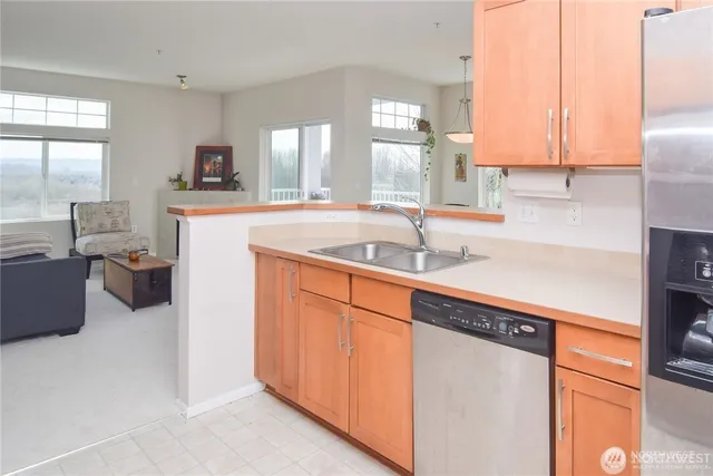 a kitchen with stainless steel appliances granite countertop a sink and a refrigerator