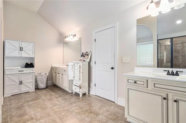 a spacious bathroom with a double vanity sink a mirror and a shower