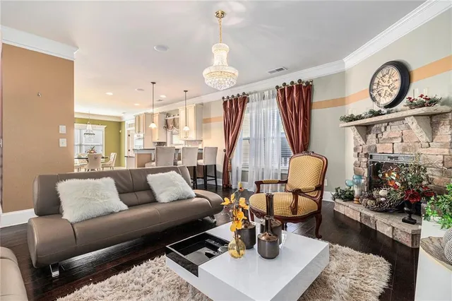 a living room with furniture a fireplace and a chandelier