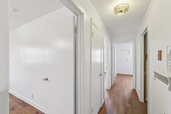 a view of a hallway with wooden floor