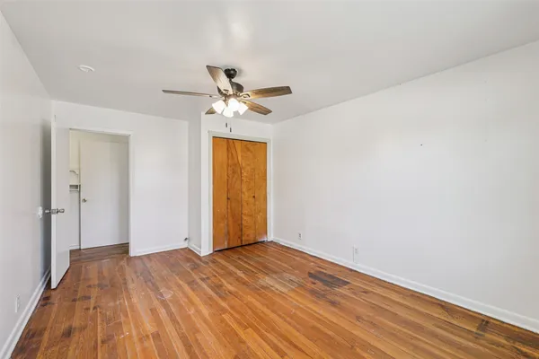 a view of room with wooden floor and ceiling fan