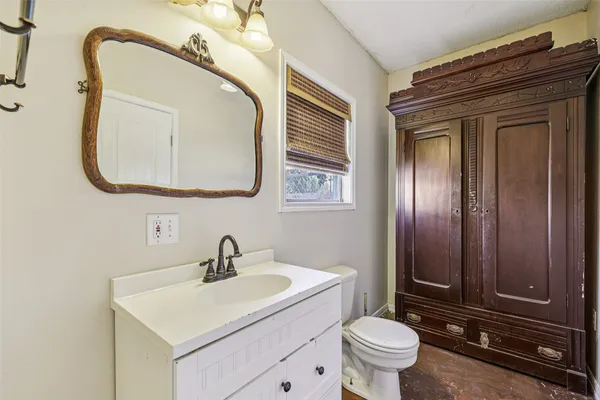a bathroom with a toilet a sink and mirror