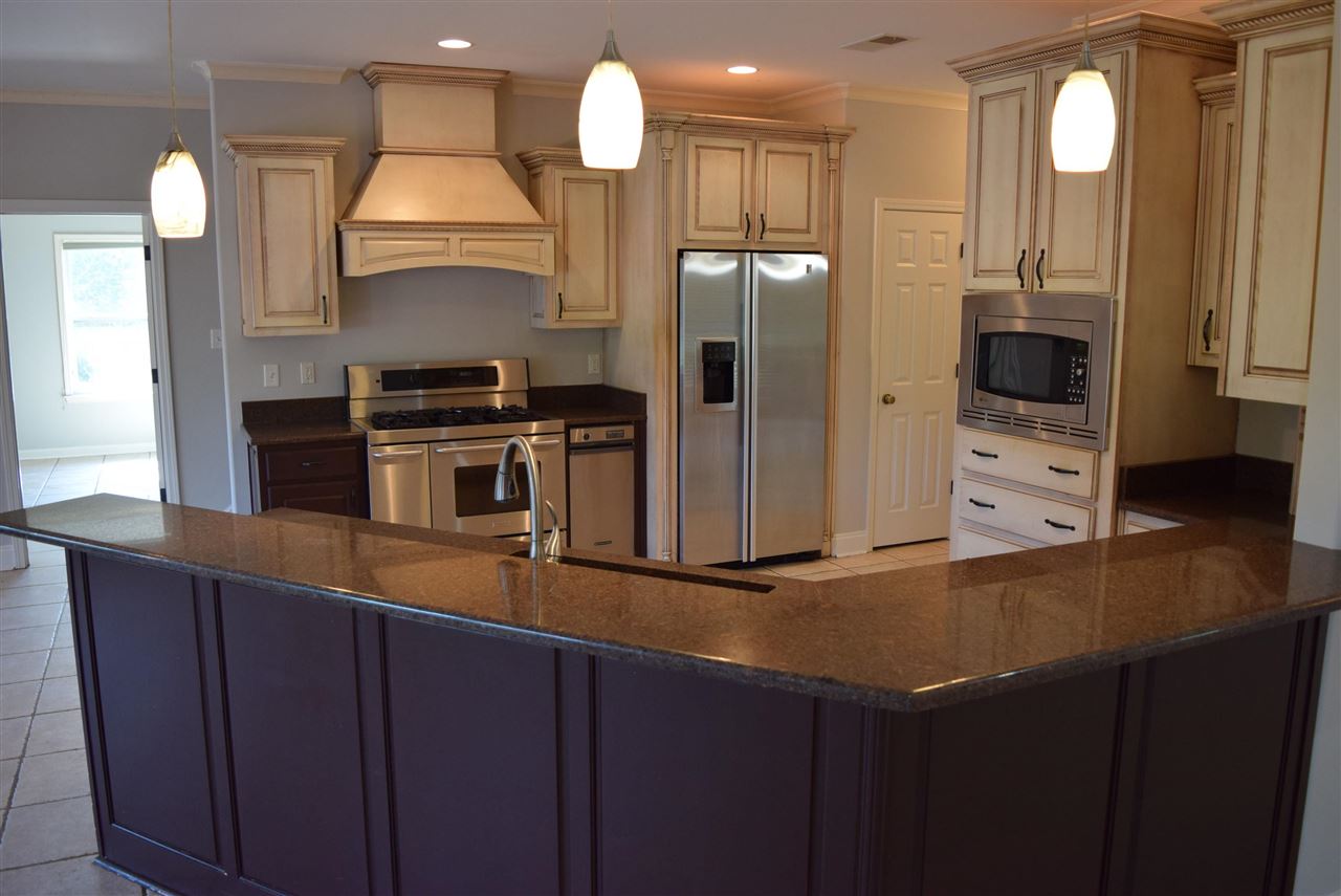 6546 Tracy Road Atoka, TN 38004 - Photo 11 of 24 a kitchen with kitchen island a counter space and a refrigerator