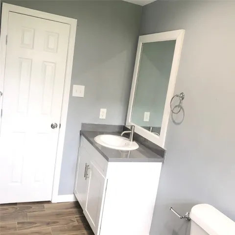 a bathroom with a granite countertop sink and a mirror