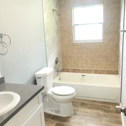 a bathroom with a granite countertop toilet a sink and a bathtub