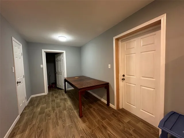a view of a hallway with wooden floor and closet