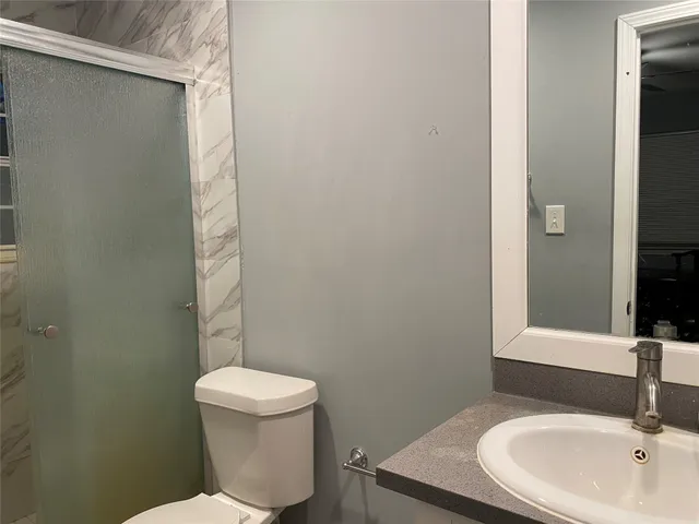 a bathroom with a sink a toilet and a mirror