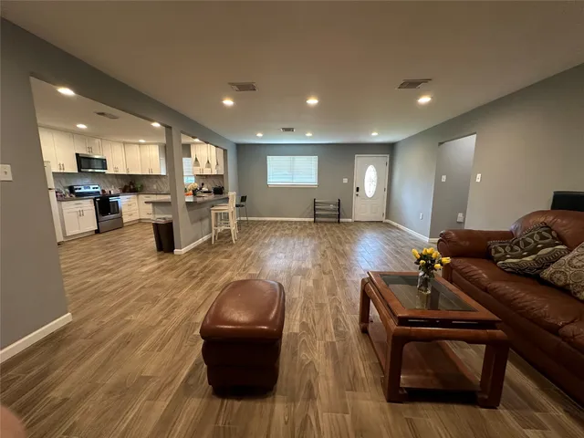 a living room with furniture and wooden floor