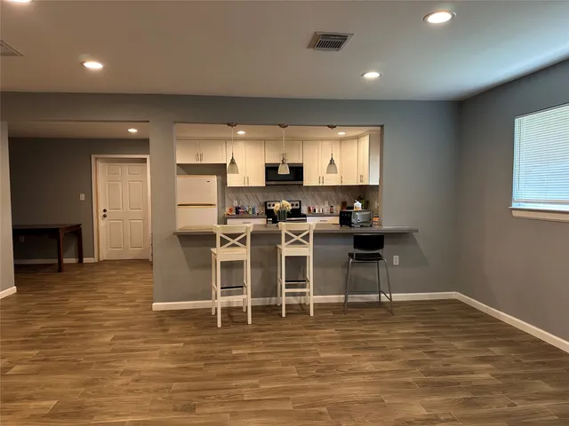 a view of a kitchen with dining room and wooden floor