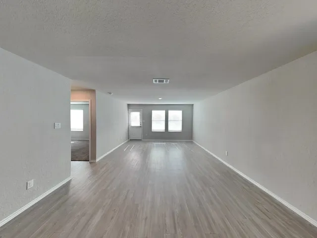 a room with stainless steel appliances kitchen island wooden floors and view living room