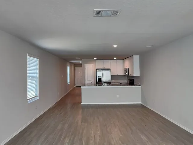 a kitchen with granite countertop a refrigerator stove and oven