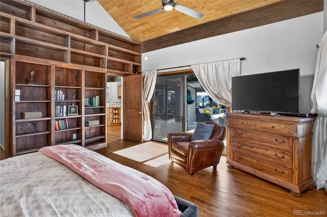 a bedroom with a large bed couch and a view of living room