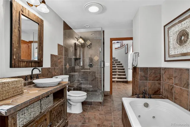 a en suite bathroom with a tub shower and mirror