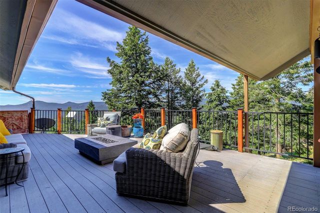 a view of deck with table and chairs potted plants with wooden floor and fence