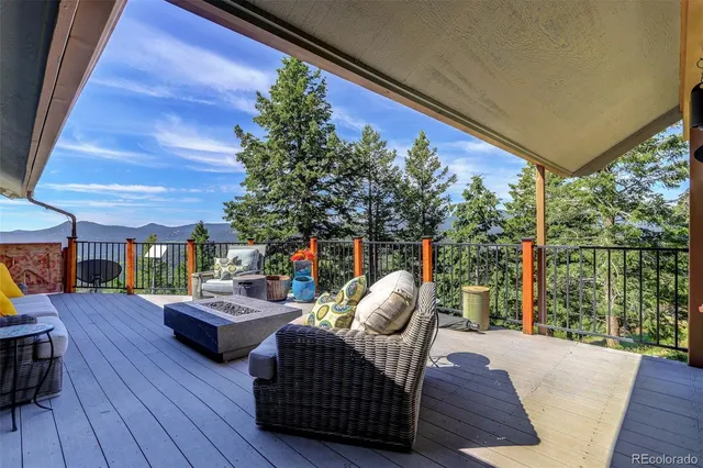a view of deck with table and chairs potted plants with wooden floor and fence