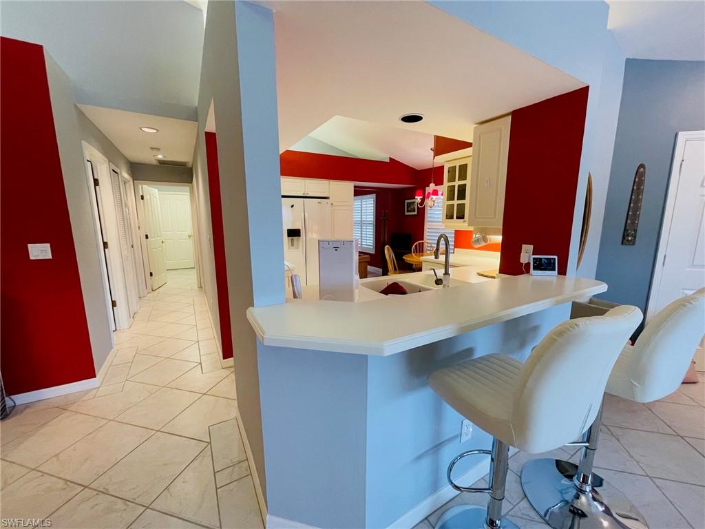 224 Napa Ridge Road East, Unit 12 Naples, FL 34119 - Photo 18 of 33 a view of kitchen island with furniture and wooden floor