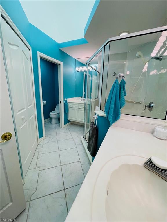 224 Napa Ridge Road East, Unit 12 Naples, FL 34119 - Photo 28 of 33 a bathroom with a sink a toilet and shower