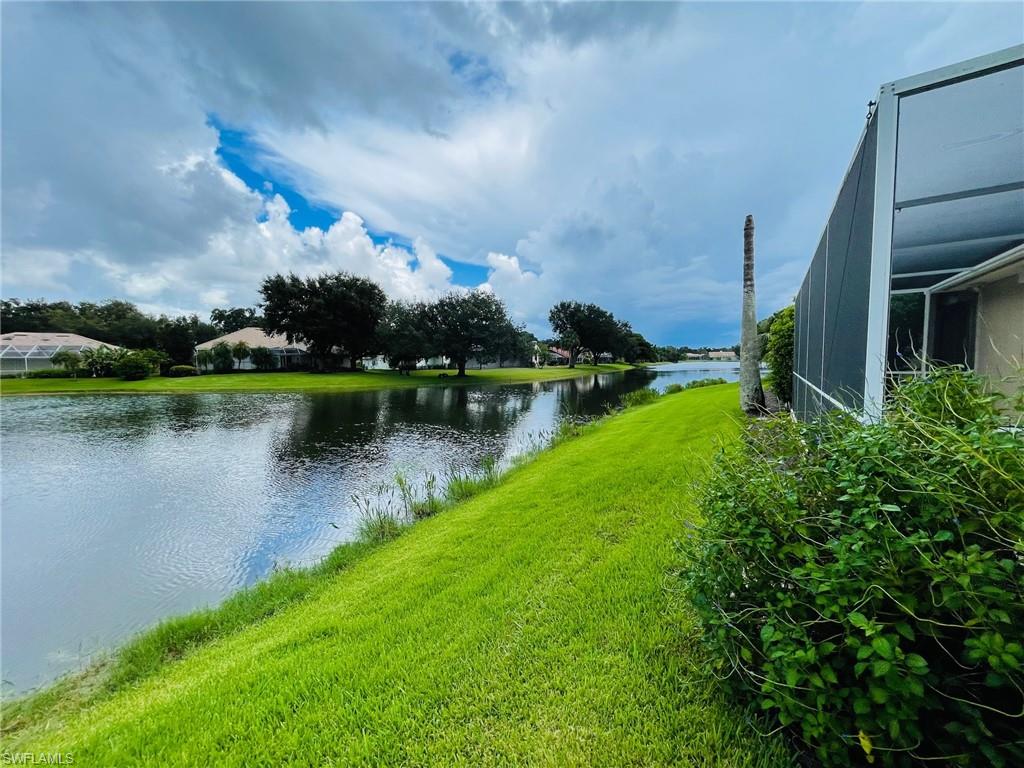224 Napa Ridge Road East, Unit 12 Naples, FL 34119 - Photo 7 of 33 a view of a lake with a house in the background