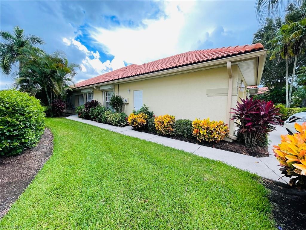 224 Napa Ridge Road East, Unit 12 Naples, FL 34119 - Photo 10 of 33 a front view of a house with a yard and potted plants