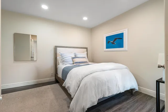 a view of a swimming pool with a bench and palm trees