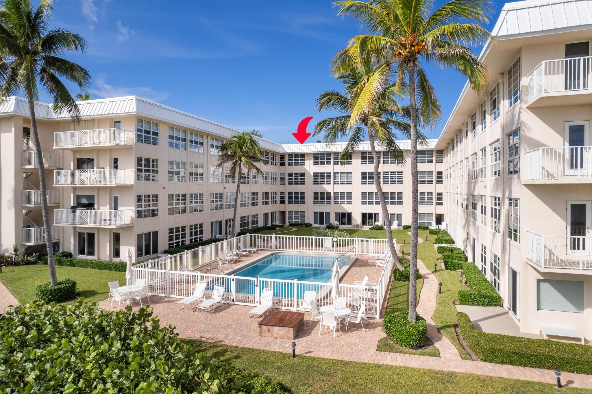3851 North Ocean Boulevard, Unit 4100 Gulf Stream, FL 33483 - Photo 23 of 27 a view of a swimming pool with a bench and palm trees