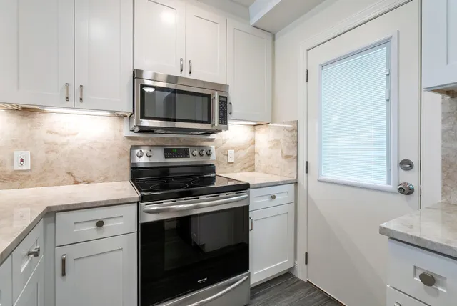 a kitchen with cabinets stainless steel appliances and a counter space