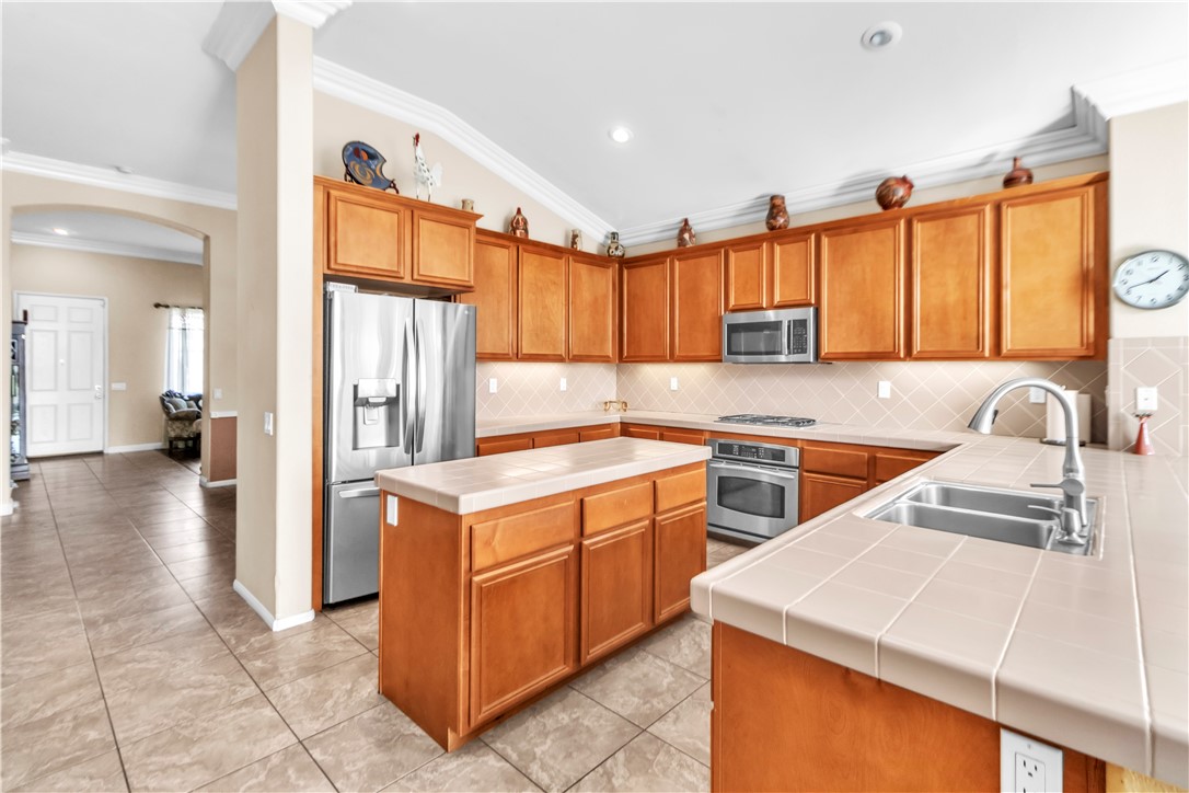 29180 Meandering Circle Menifee, CA 92584 - Photo 11 of 16 a kitchen with a sink stove and refrigerator