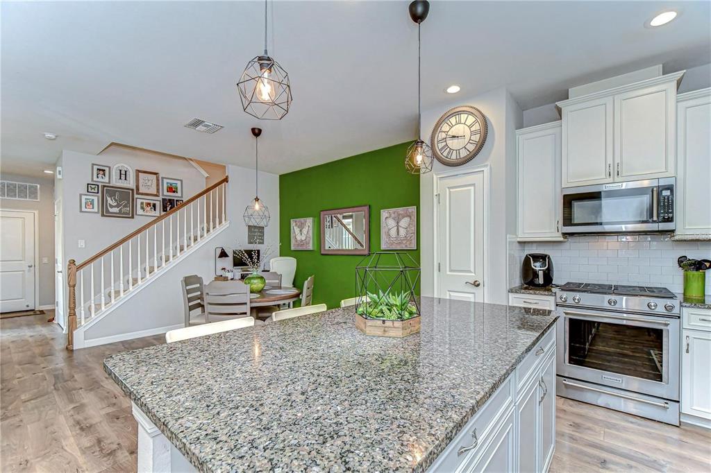 5703 Colony Glen Road Lithia, FL 33547 - Photo 11 of 53 a view of a kitchen with granite countertop stainless steel appliances a stove center island a stove cabinets a rug and a window