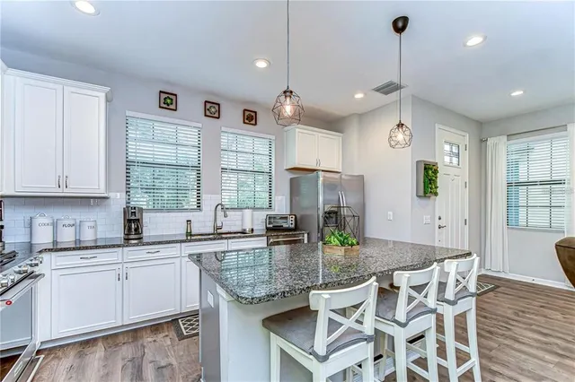 a kitchen with kitchen island granite countertop wooden cabinets and white appliances