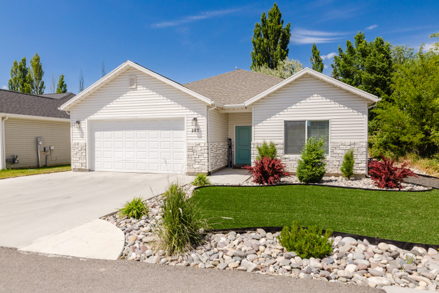 287 East 1000 North Logan, UT 84321 - Photo 3 of 41 Ranch-style exterior featuring white horizontal siding and a stone facade