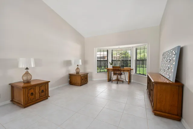 a dining room with furniture and a chandelier fan