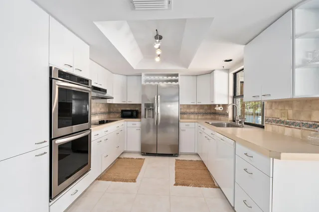 a kitchen with a dining table chairs and refrigerator