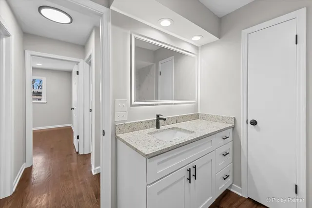 a bathroom with a granite countertop sink and a mirror