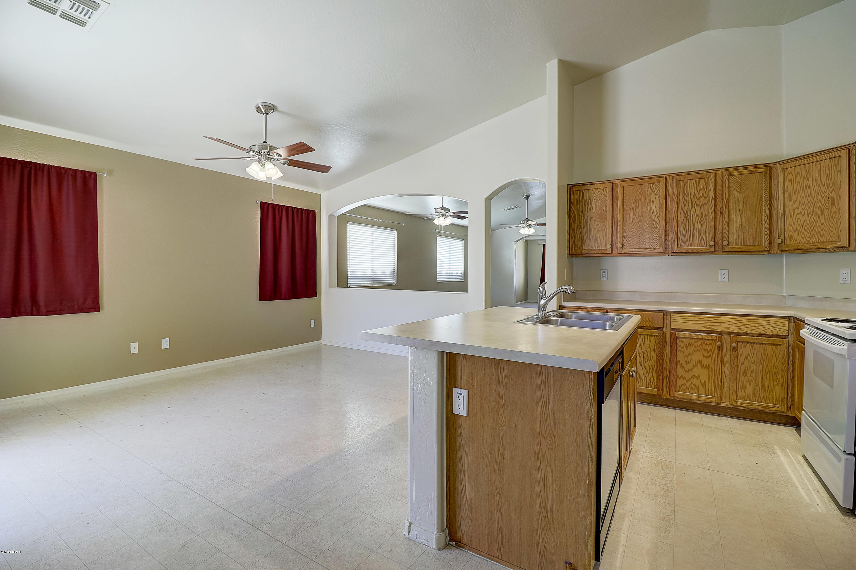 8461 West Riley Road Tolleson, AZ 85353 - Photo 12 of 25 a kitchen with kitchen island granite countertop a sink cabinets and stainless steel appliances