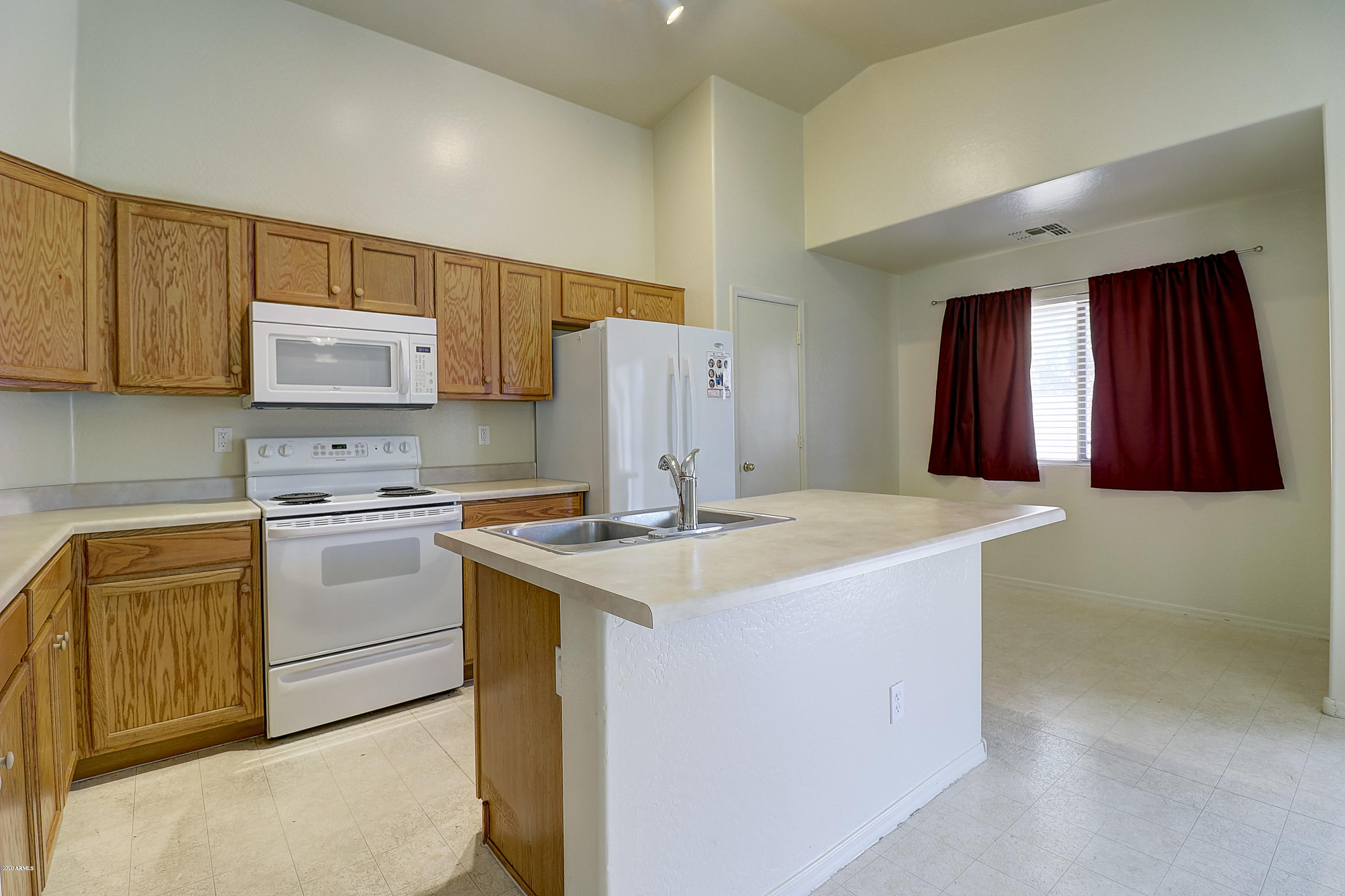 8461 West Riley Road Tolleson, AZ 85353 - Photo 13 of 25 a kitchen with a sink stove and refrigerator