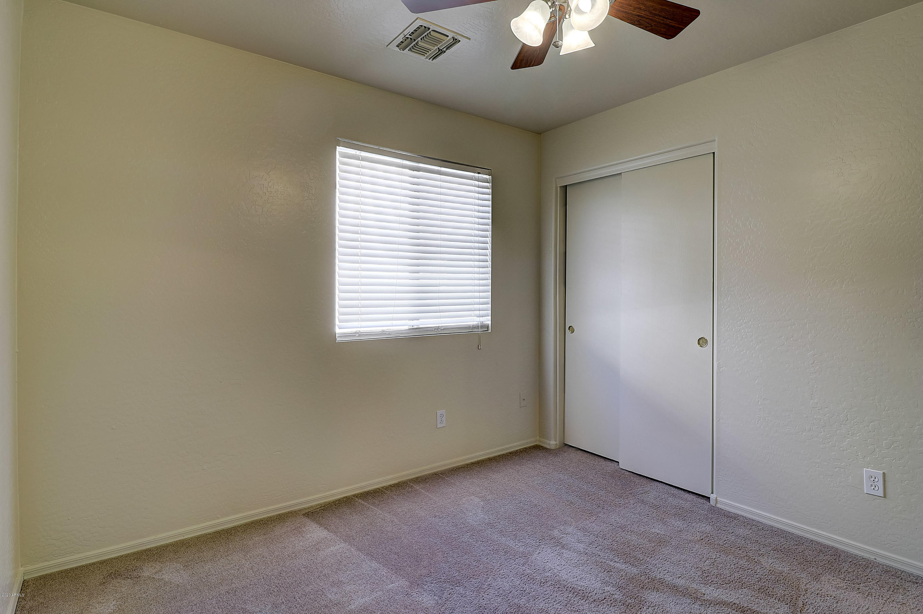 8461 West Riley Road Tolleson, AZ 85353 - Photo 20 of 25 an empty room with a window and a ceiling fan