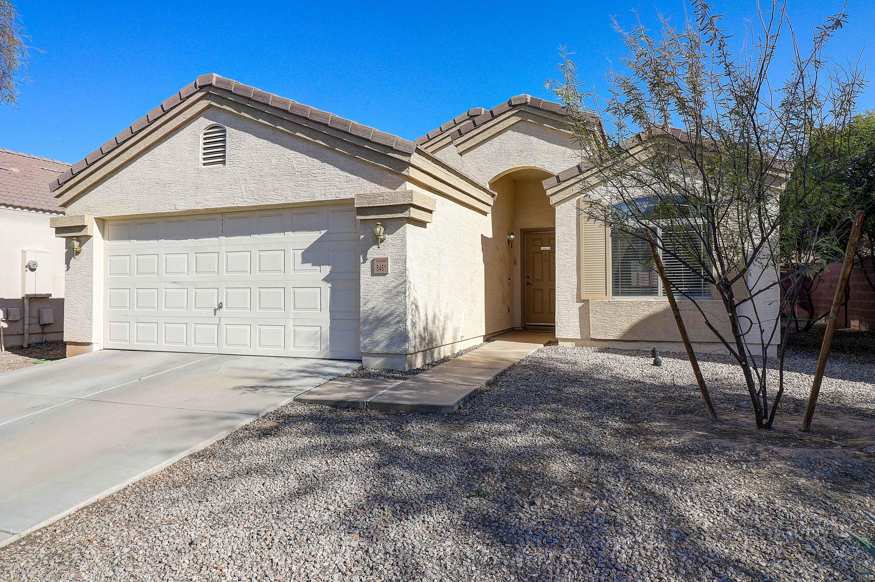 8461 West Riley Road Tolleson, AZ 85353 - Photo 2 of 25 a front view of a house with a yard and garage