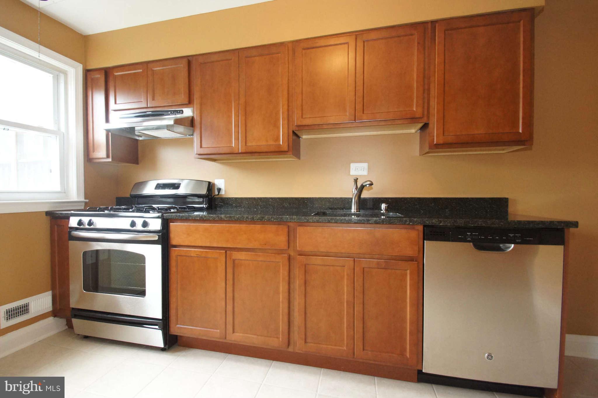1423 Langford Road Baltimore, MD 21207 - Photo 12 of 30 a kitchen with stainless steel appliances granite countertop a stove a sink and a microwave