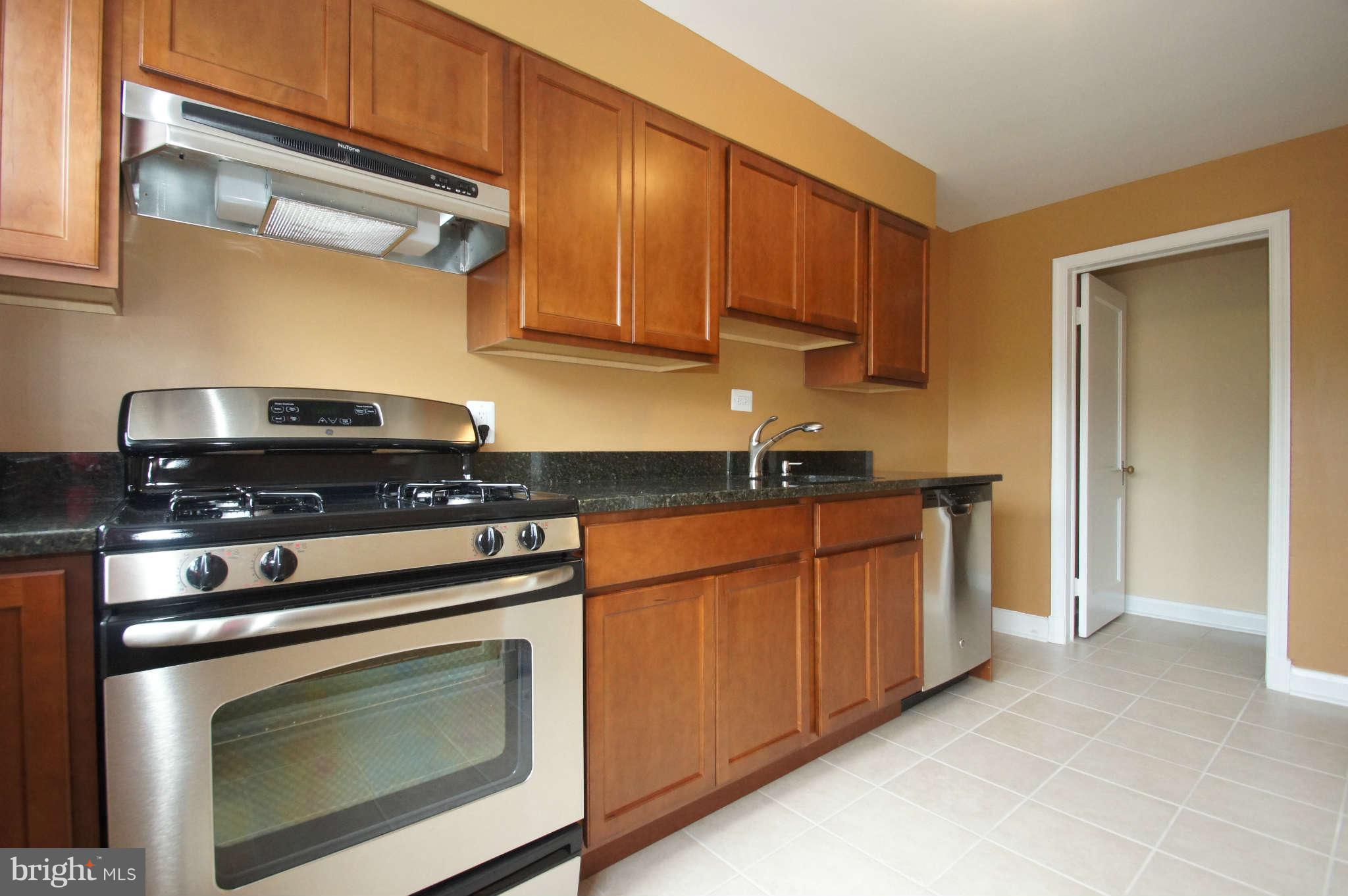 1423 Langford Road Baltimore, MD 21207 - Photo 13 of 30 a kitchen with stainless steel appliances granite countertop a stove and a microwave