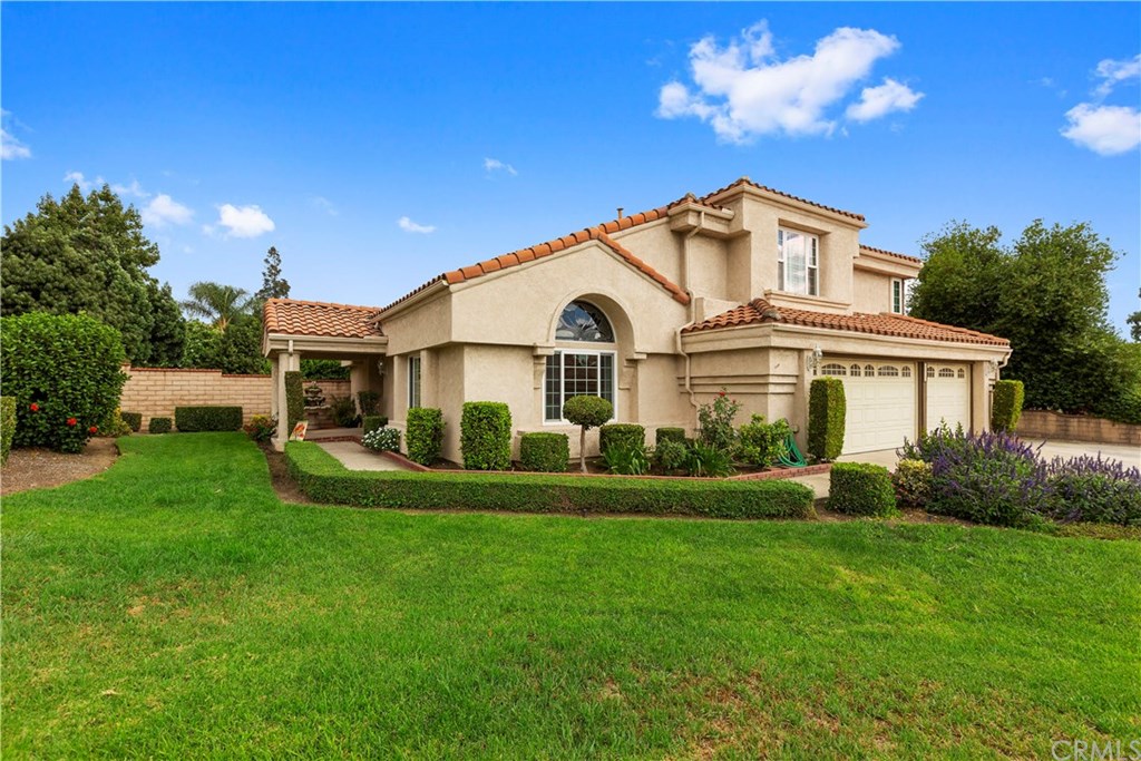 a front view of a house with a garden and yard