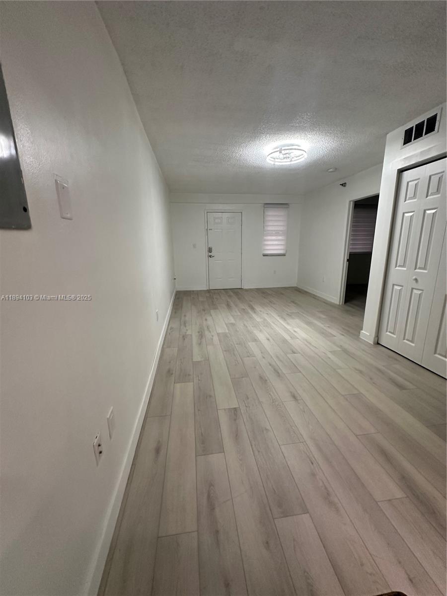 1852 Southwest 7th Street, Unit 109 Miami, FL 33135 - Photo 11 of 21 an empty room with wooden floor and windows
