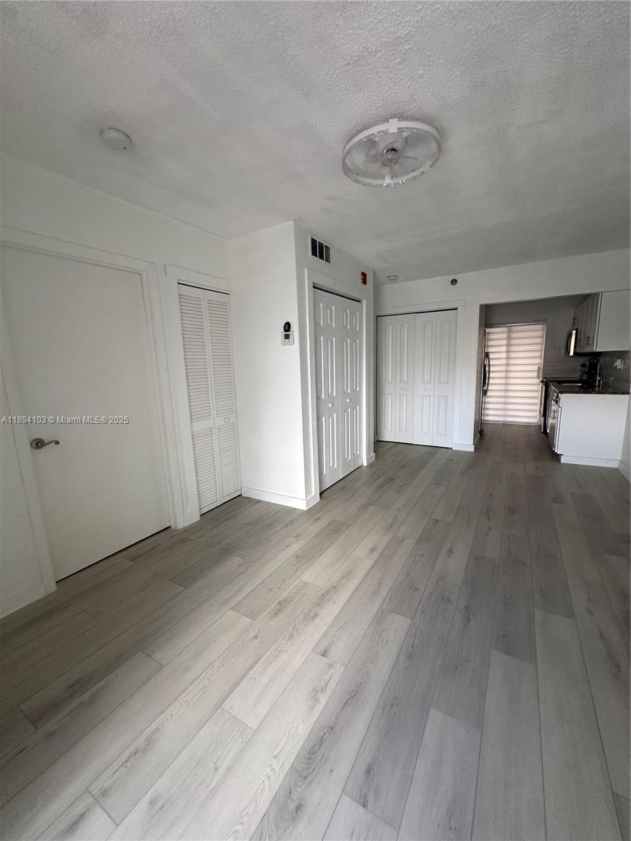 1852 Southwest 7th Street, Unit 109 Miami, FL 33135 - Photo 6 of 21 a view of empty room with wooden floor and window